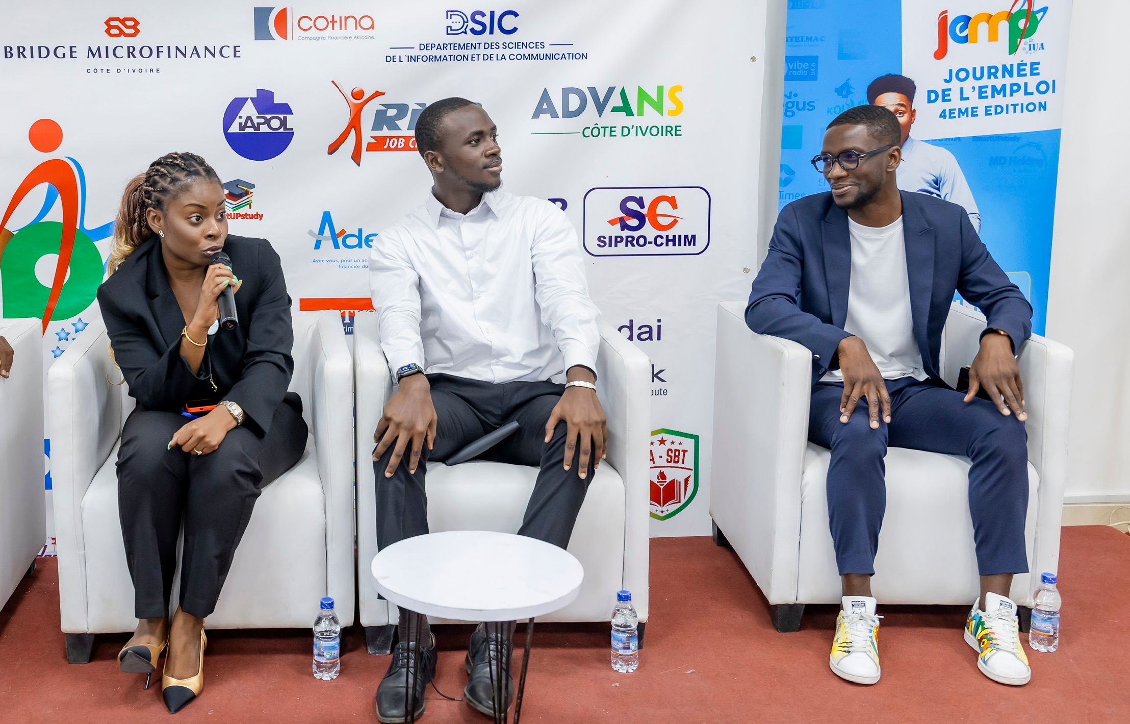 Table ronde de trois intervenants, dont Axel Loupeda, sur scène lors de la Journée de l'Emploi de l'Institut Universitaire d'Abidjan