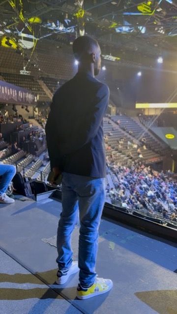 Axel Loupeda de dos sur la scène de l'Accor Arena, face à une salle pleine