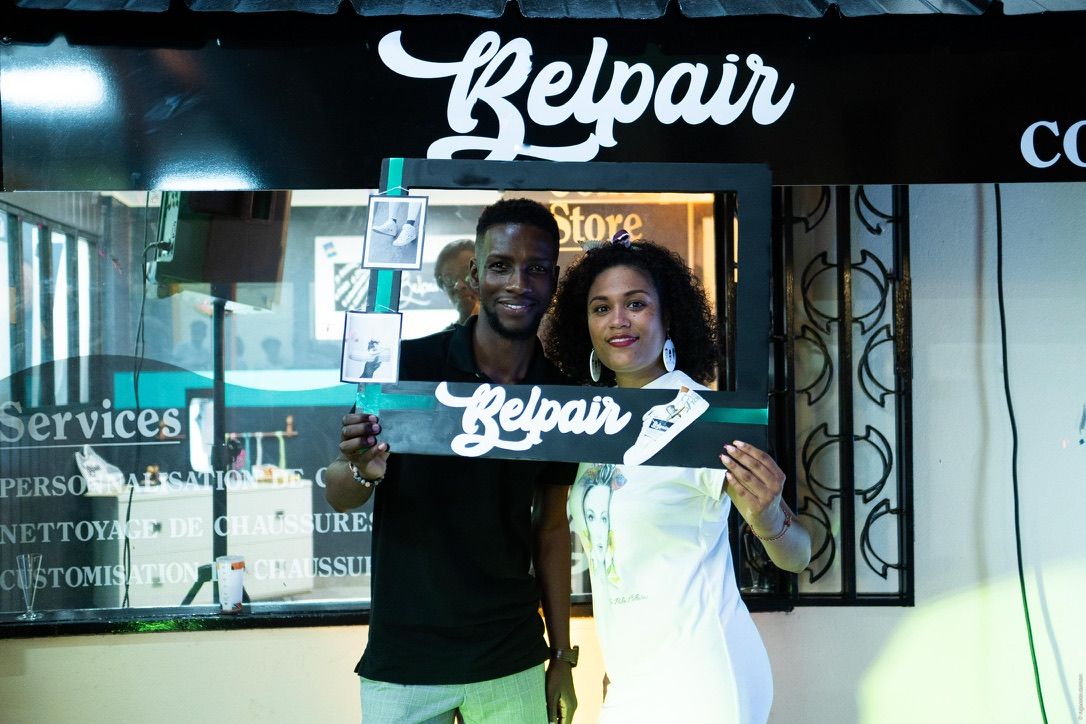 Axel Loupeda tient un panneau Belpair devant la vitrine illuminée du concept store, lors de l'inauguration